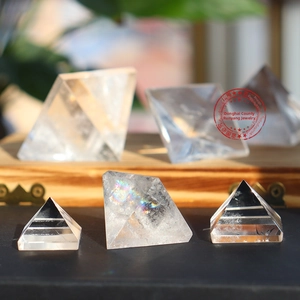 Macro shot of natural clear quartz pyramids showing rainbow reflections and ice cracks