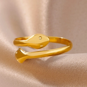 Macro shot of minimalist gold snake ring featuring an open adjustable band on silk cloth