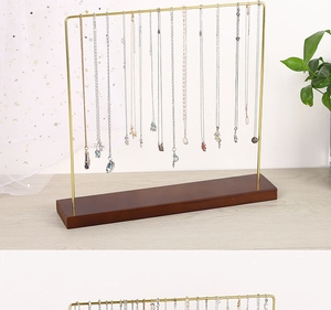 Golden metal necklace organizer stand with a stable wooden base for jewelry display