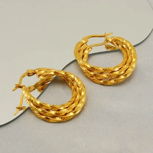 Elegant gold twisted rope hoop earrings with a mirror-finish polished metal surface