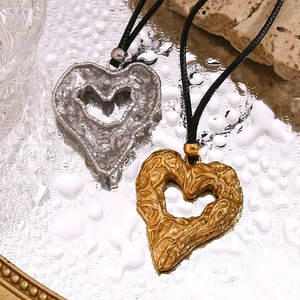 Detail of 18K gold and silver plated heart necklaces with unique wax-melt texture finish
