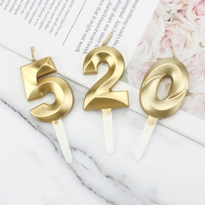 Golden 520 number birthday candles with 3D diamond texture on marble surface
