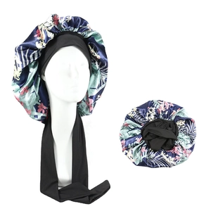 Detail of satin floral sleep bonnet with adjustable black elastic strap for hair protection