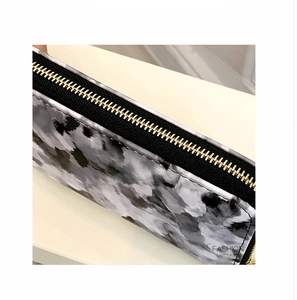Detailed close-up of marble pattern lady's purse with golden zipper and fine stitching