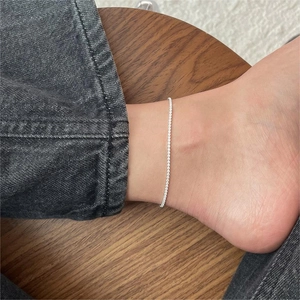 Detail view of S925 sterling silver anklet with sparkling zircon on a model's ankle