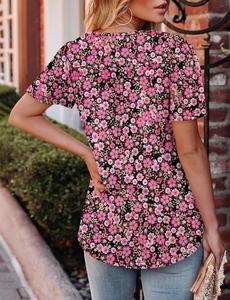 Outdoor back view of a floral print short sleeve t-shirt with pink and purple blossoms