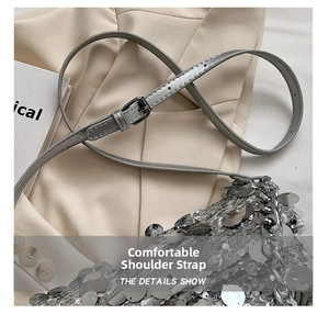 Detailed view of gray leather adjustable strap with silver buckle on sequin handbag