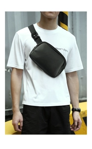 Detail of a minimalist black sports fanny pack worn across the chest on a white t-shirt
