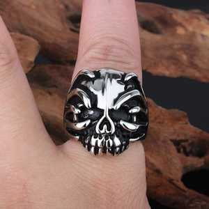 Detailed view of skull ring with claw design on hand with weathered wood background