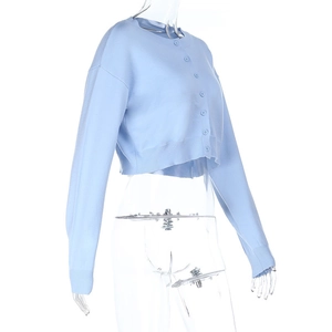 Détail du cardigan en maille bleu clair avec boutons assortis et texture du tissu
