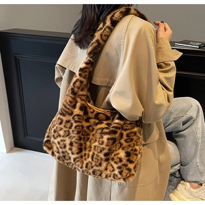 Détail d'un sac porté épaule en fausse fourrure léopard avec un trench-coat beige