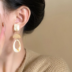 Retro resin teardrop earrings with wooden geometric accents worn by a model