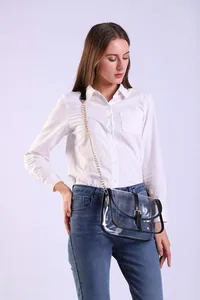 Detailed view of clear PVC saddle bag with black leather trim and gold chain strap