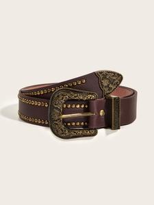 Dettaglio cintura vintage in pelle bordeaux con fibbia scolpita in bronzo antico e borchie