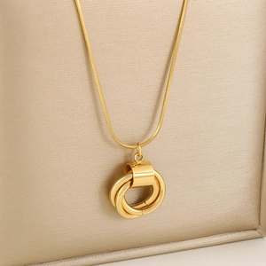 Detail of interlocking triple rings pendant on a polished gold snake chain necklace