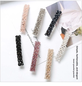 Detailed macro view of seven handcrafted beaded hair clips in various elegant colors