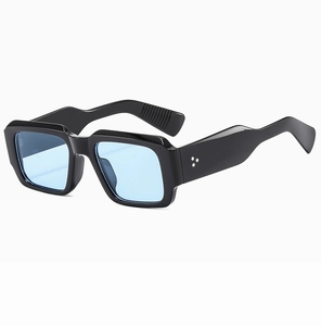 Detail shot of black oversized sunglasses with light blue lenses and silver rivets