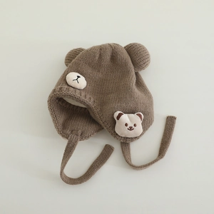 Detailaufnahme der braunen Strickmütze für Babys mit Bärenohren und Strickmuster-Struktur