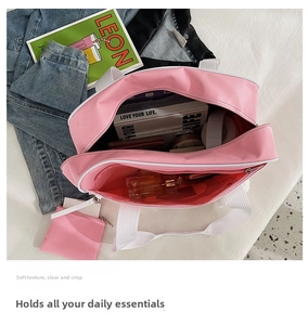Detail view of pink canvas tote bag interior with multiple compartments and a small pouch