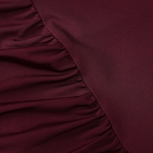 Detailed view of ruched burgundy fabric with subtle horizontal texture and elastic drape