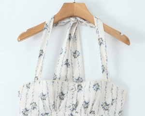 Detail of floral halter neck dress with decorative front buttons and blue flower print