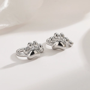Detailed view of silver cat paw ear cuffs with polished mirror finish and cute animal design