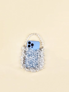 Detail shot of clear acrylic beaded handbag with faceted beads and metallic connectors