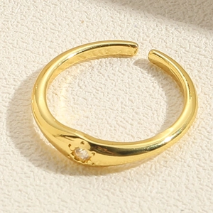 Detailed close-up of a double-layer open gold ring featuring a sparkling zircon stone