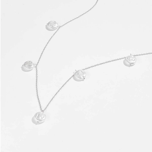 Dettaglio della collana in argento S925 con cinque perle bianche su sfondo bianco