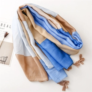 Flat lay of a color-block cotton linen scarf with tassels and decorative magazine