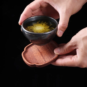 Japanese style lotus root shaped beech wood coaster with dark ceramic tea cup