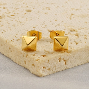 Minimalist 18k gold plated stainless steel pyramid stud earrings on a stone base