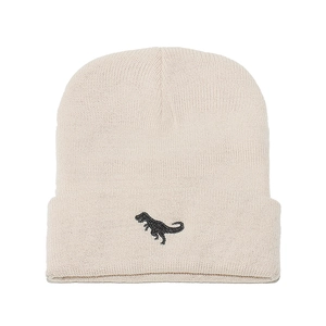 Close-up of cream knit beanie with black dinosaur embroidery and ribbed texture details