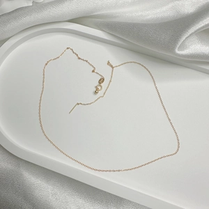 Close-up of minimalist gold S925 silver chain with O-ring link and pin needle pendant
