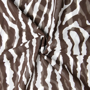 Detail of soft brown and white zebra print chiffon fabric with smooth draped texture