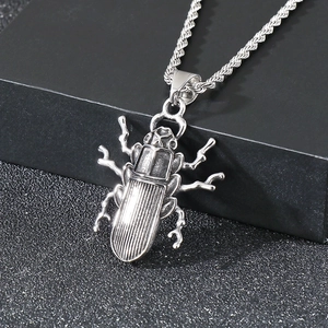 Macro view of vintage beetle pendant in distressed steel on a twisted rope chain