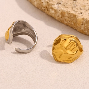 Detailed view of irregular hammered 18K gold plated snake head rings on stone base