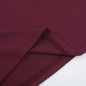 Primer plano del vestido de punto granate mostrando costuras de precisión en el dobladillo