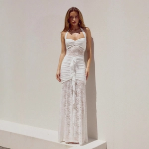 Detail of white lace halter maxi dress featuring ruffle trim and sheer mesh texture