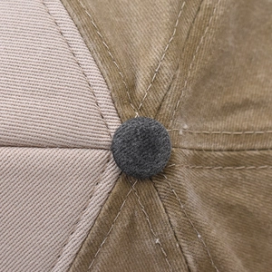 Macro detail of the washed cotton fabric and top button on this distressed baseball cap