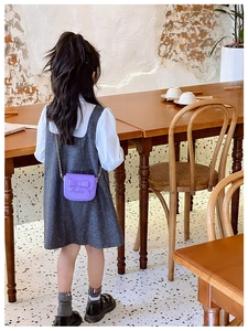 Girl wearing a purple mini crossbody bag with a bow knot in a cozy cafe setting