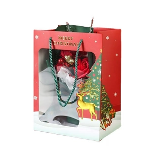 Red Christmas gift bag with transparent window and gold reindeer print on white background