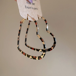 Detailed view of heart-shaped hoop earrings with leopard print pattern and metal frames