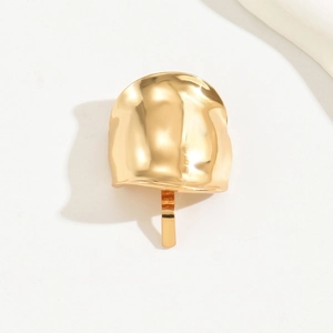Detailed close-up of a gold-finish metal hair hook with textured surface craftsmanship
