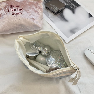 Detail of velvet makeup bag featuring Shine Like the Stars embroidery and crystal accents