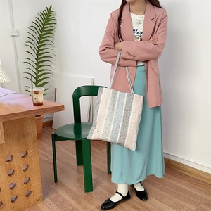 Gros plan du sac cabas en toile fleurie avec étiquette Soonku et motifs de fleurs bleues