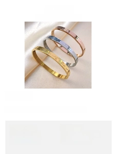 Detail view of 58mm titanium steel bangles showing Forever Love engraving and heart pattern