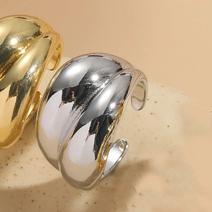 Close-up of wide irregular open rings in gold and silver finish with mirror polishing