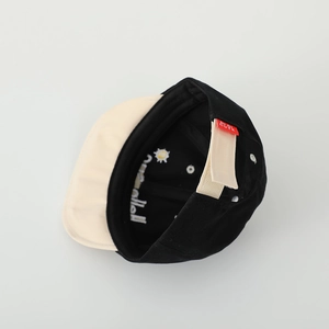 Détail d'une casquette bébé en coton avec fermeture velcro réglable et broderie