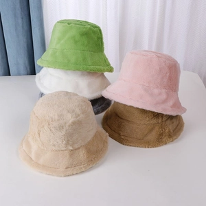 Detailed pile of plush faux rabbit fur bucket hats in green, pink, beige, and brown colors